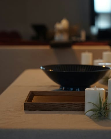 Spa table with bowl and candles on white linen