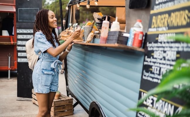Woman ordering from a food truck at a festival